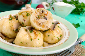 Ukrainian dumplings with meat and mushrooms in a bowl on a bright background. Top view.