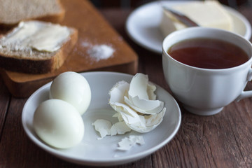 Fototapeta na wymiar rustic Breakfast in the morning, bread and butter, boiled eggs and tea