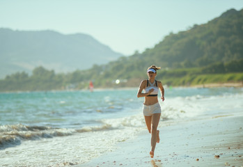 healthy woman jogger on seacoast in evening running