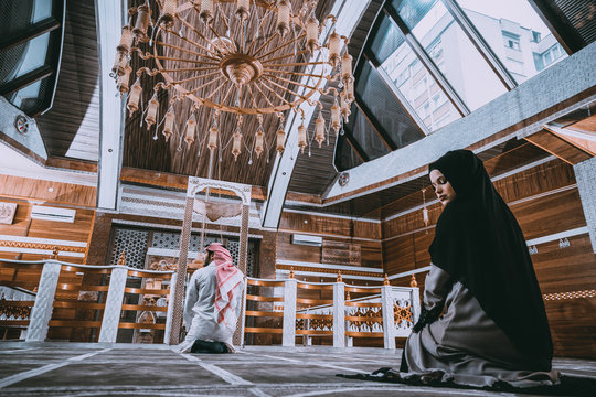 Muslim man and woman praying in mosque