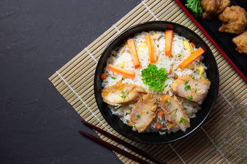 Fried rice with korean style chicken on black table