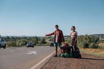 Hitchhiking couple. Backpackers on road
