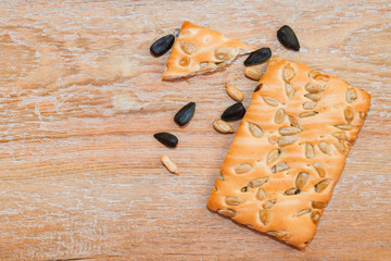 Cookies made from wheat and oatmeal flour with organic sunflower seeds, healthy and diet food on wooden background, vintage