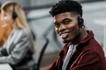 selective focus of african american call center operator looking at camera in office