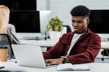 young african american businessman at workplace with laptop in office