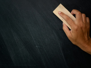Hand holding brush eraser and blackboard , Concept education and school..