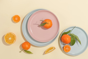 Fresh juicy tangerines, pomegranates and sliced fruits on a yellow background. Summer mood, healthy food. Top view.