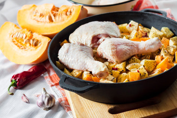 Cooking one-pot meal - chicken thighs and legs with potatoes and pumpkin