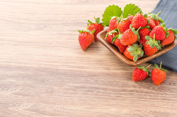 A plate of beautiful strawberries isolated on wooden background, close up, macro.