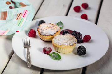 Cottage cheese pancakes, syrniki, curd fritters with fresh berries on white wooden background