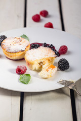 Cottage cheese pancakes, syrniki, curd fritters with fresh berries on white wooden background