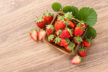 A plate of beautiful strawberries isolated on wooden background, close up, macro.