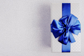 Gift box with blue ribbon on Silver background