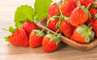 A plate of beautiful strawberries isolated on wooden background, close up, macro.