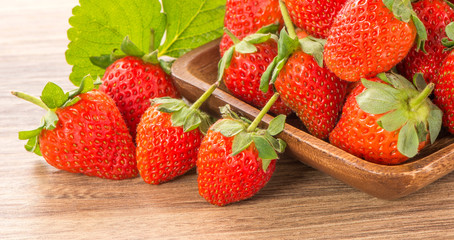 A plate of beautiful strawberries isolated on wooden background, close up, macro.