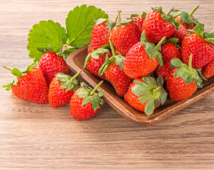 A plate of beautiful strawberries isolated on wooden background, close up, macro.