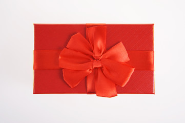 Single red gift box with ribbon on white background.