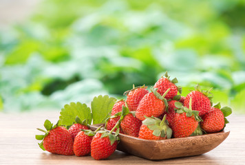 A plate of beautiful strawberries isolated on wooden background, close up, macro.