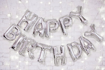 birthday party decoration - happy birthday letters air balloons over brick wall with lights