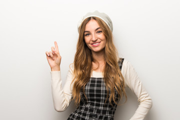 Fashionably woman wearing hat showing and lifting a finger in sign of the best