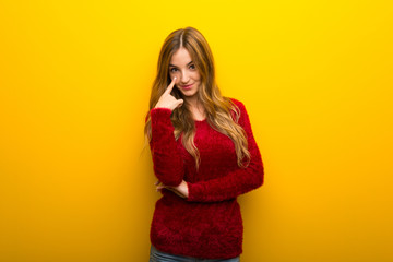 Young girl on vibrant yellow background looking to the front