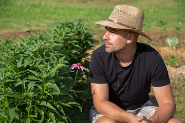 Young man with hat Working in a Home Grown Vegetable Garden