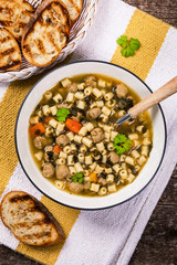 Traditional Italian-Style Wedding Soup. Made with Meatballs, Carrots and Spinach in Chicken Broth. Selective focus.