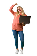 A full-length shot of a Young girl with laptop and celebrating a victory on isolated white background