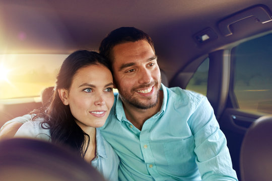 Transportation, Road Trip And People Concept - Happy Man And Woman Riding In A Taxi Back Seat