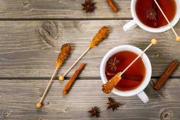 Cup of autumn winter hot spicy tea with cinnamon, anise and honey on a wooden background, top view. Selective focus.