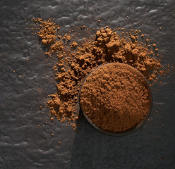 Cocoa powder pile in bowl from top view or above isolated on white background