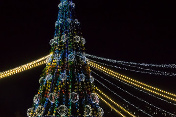 Decorated Christmas tree with multi-colored lights at night