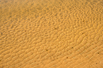 shallow surf with sand of a beach with patterns