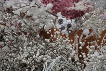 New Year's decor from white artificial branches and ornaments and brown cones