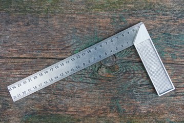 gray metal square tool lies on a wooden board