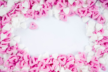 Valentine's sweets background, white background with sugar hearts sweet sprinkles, copy space top view, layout on white