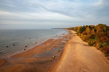 sandy sea beach with rocks and low tide in overcast day