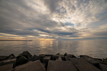 dramatic high contrast clouds in sunset over seaside beach