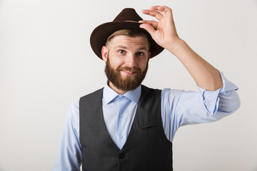 Handsome young bearded man standing isolated over white wall background posing.