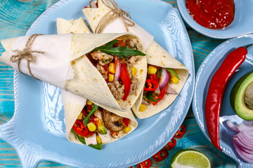 Tortilla, burritos, sandwiches twisted rolls. beef burritos with beef, avocado beans, and vegetables, salsa, peppers on wooden rustic textures. place for text