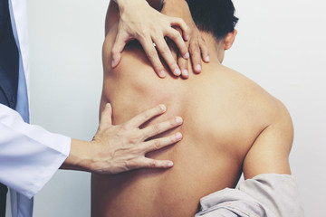 Closeup of Doctor examines or treatment the man with shoulder pain or neck pain on white...