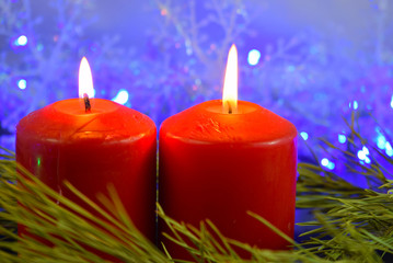 Red candles on the background of lights.Christmas card.