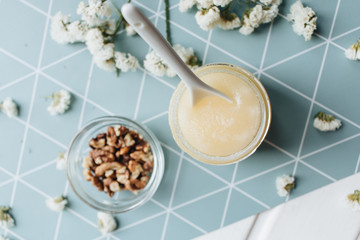Walnuts, honey and white flowers on table