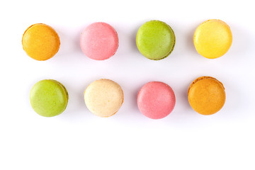 Two rows of colorful French macarons isolated on white. Top view with copy space.