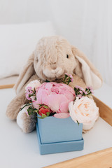 Beautiful spring bouquet with tender flowers in box and teddy rabbit