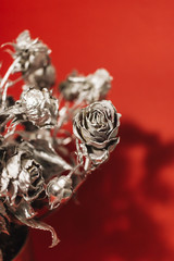 Christmas decoration with silver roses on red background
