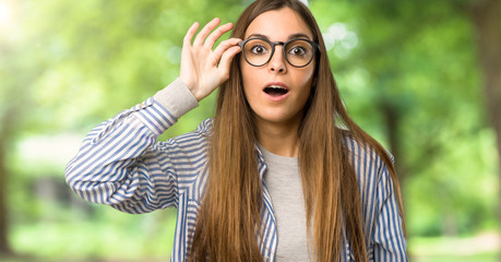 Young girl with striped shirt with glasses and surprised at outdoors