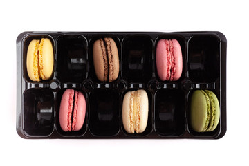 Colorful French macarons in a package with empty slots - top view