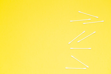 Cotton buds isolated on yellow background, plastic cotton swabs