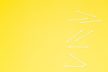 Fototapeta premium Cotton buds isolated on yellow background, plastic cotton swabs